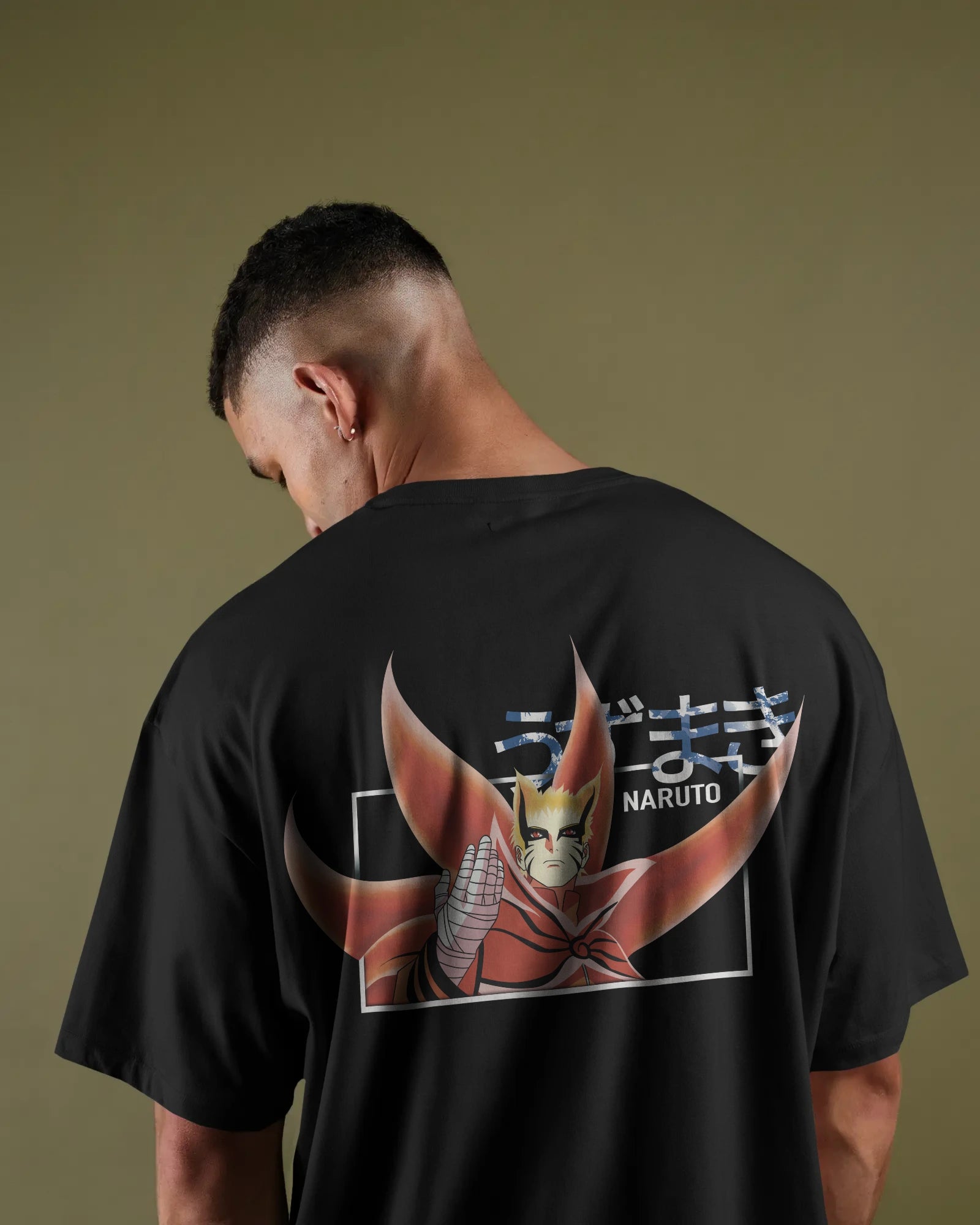 Person wearing a black t-shirt with a 'Naruto' graphic on the back against a green background